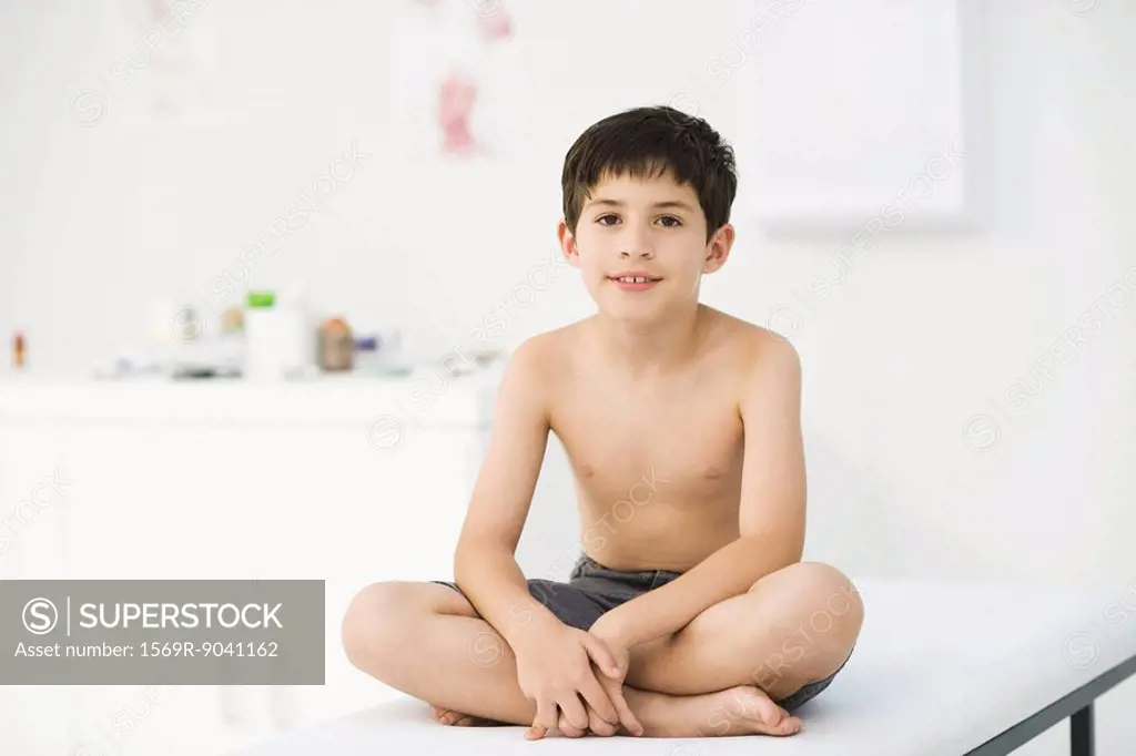 Boy sitting on examining table in doctor´s office