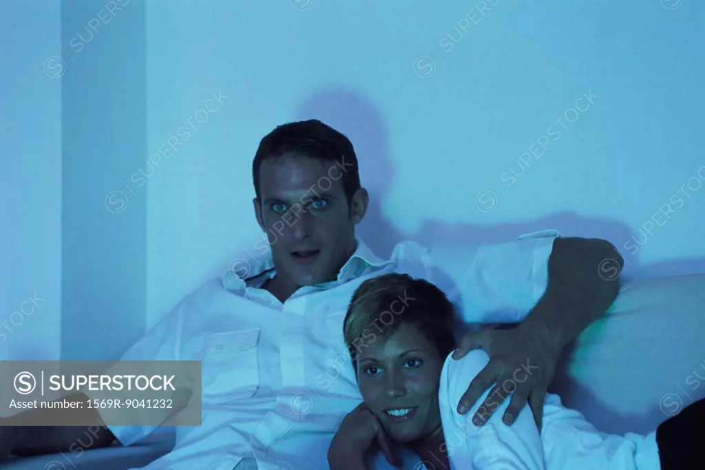 Couple watching TV together at night