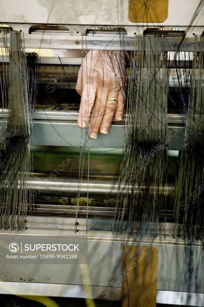 Fabric coating plant, weaving department, mechanist preparing weaver´s reed on loom
