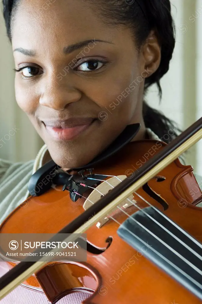 Young woman playing violin, portrait
