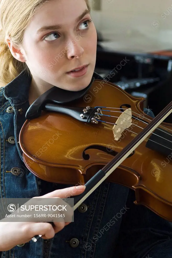 Young woman practicing violin