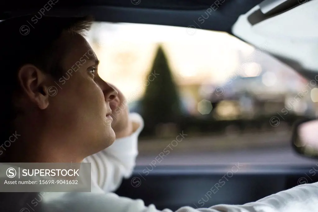 Man driving, lost in thought