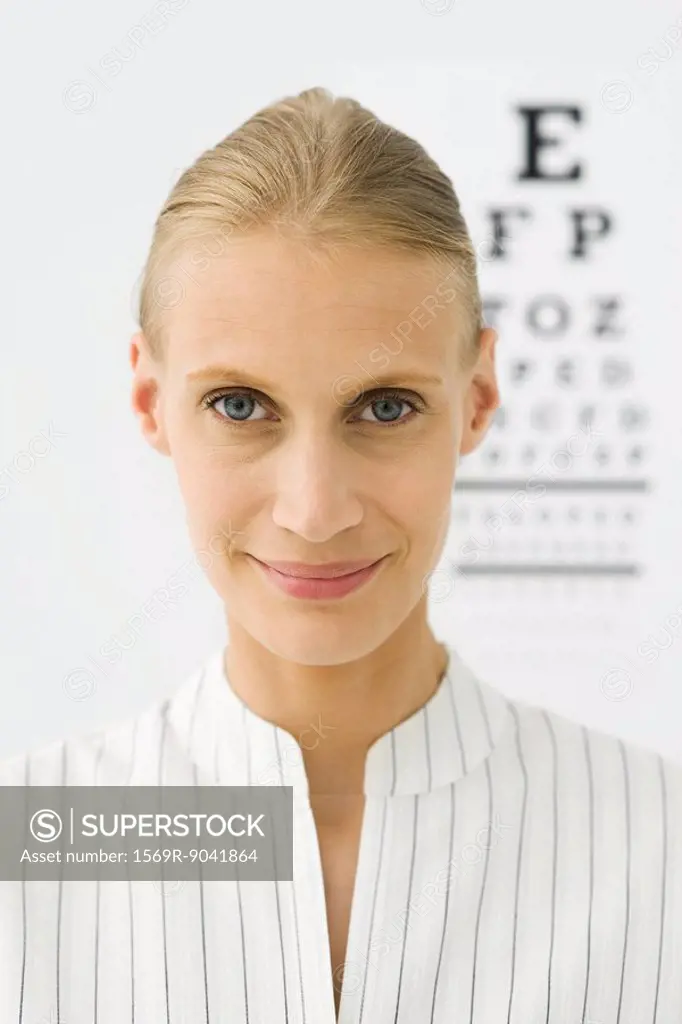 Young woman, eye chart in background, portrait