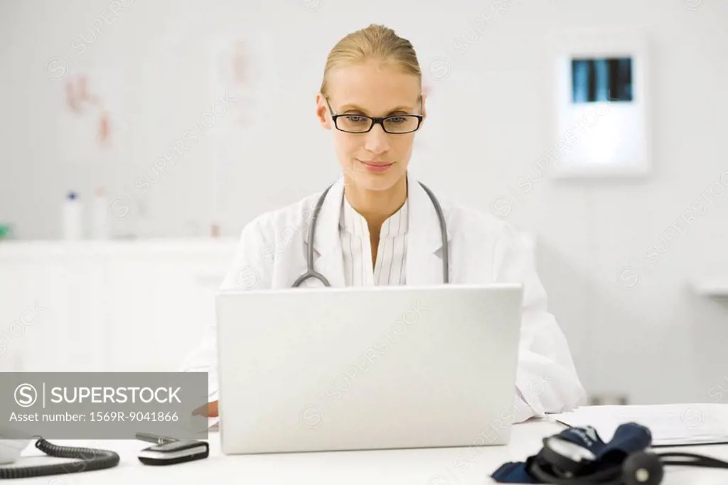 Female doctor using laptop at desk