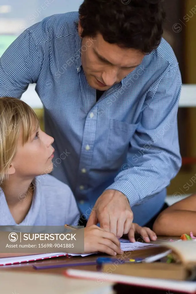 Teacher helping elementary school student in class