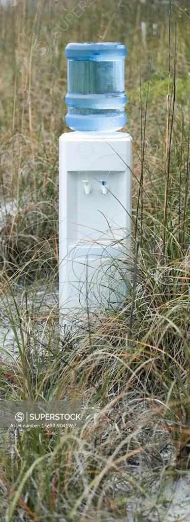 Water cooler in field of dry grass