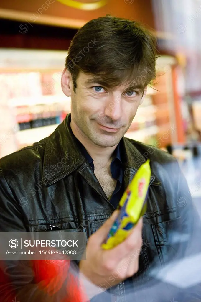 Man at convenience store checkout counter buying snack
