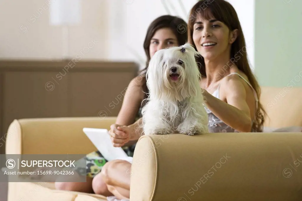 Woman relaxing with pet dog and teenage daughter