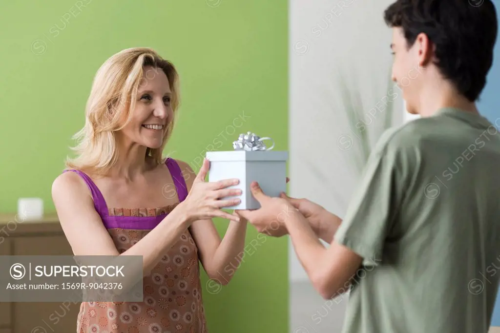 Teenage son presenting gift to mother