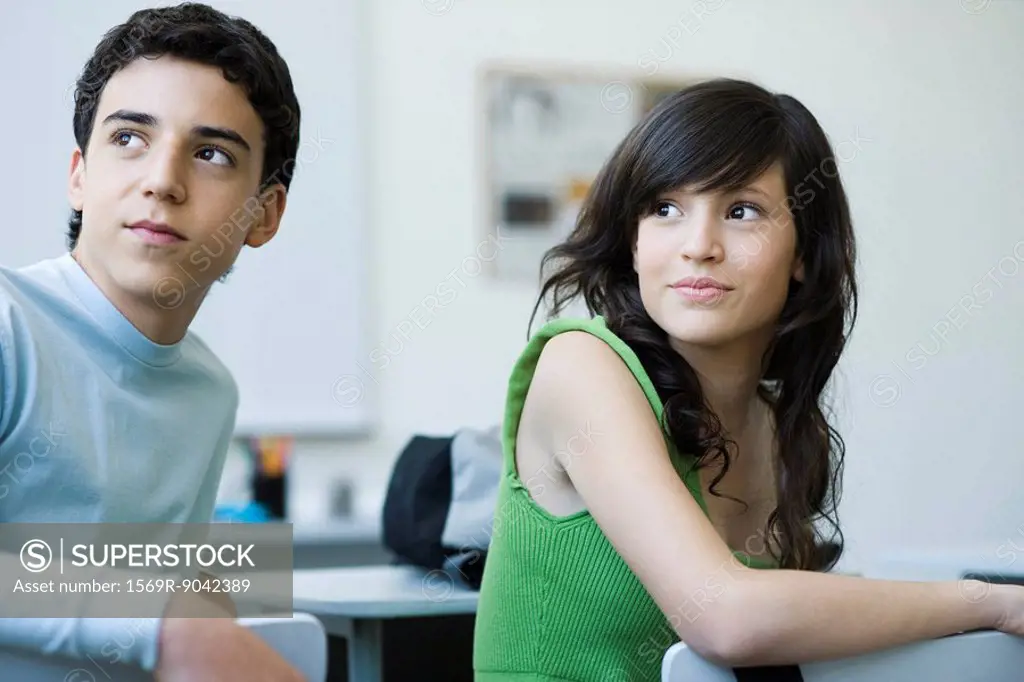 High school students in class, looking over shoulders with interest