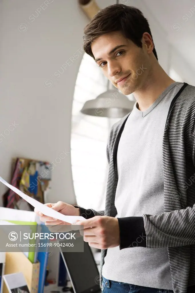 Man with look of satisfaction holding document