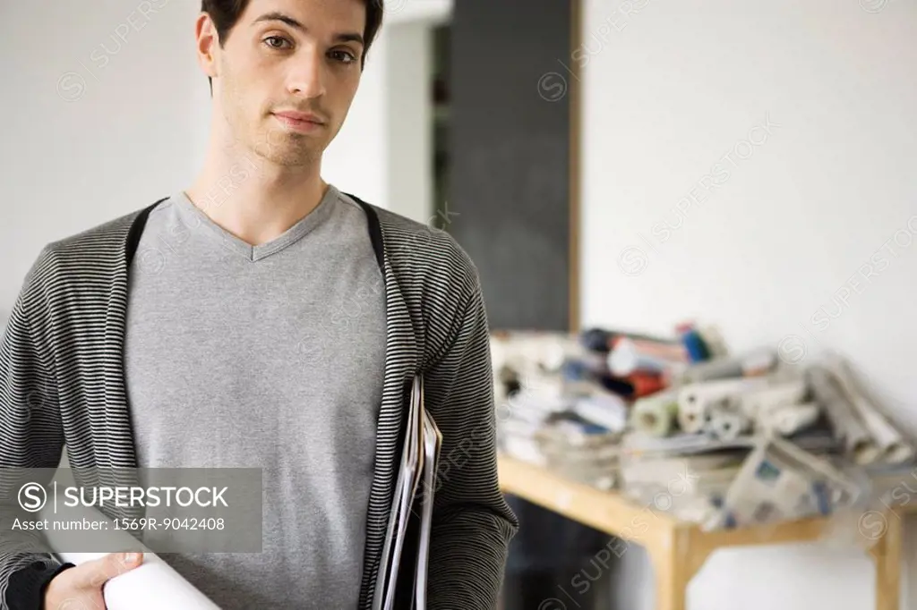 Man carrying rolled up blueprint under arm