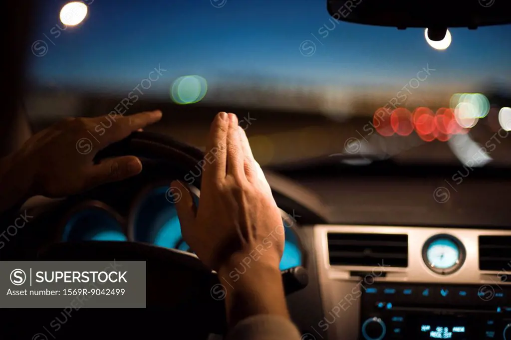 Driver drumming hands on steering wheel