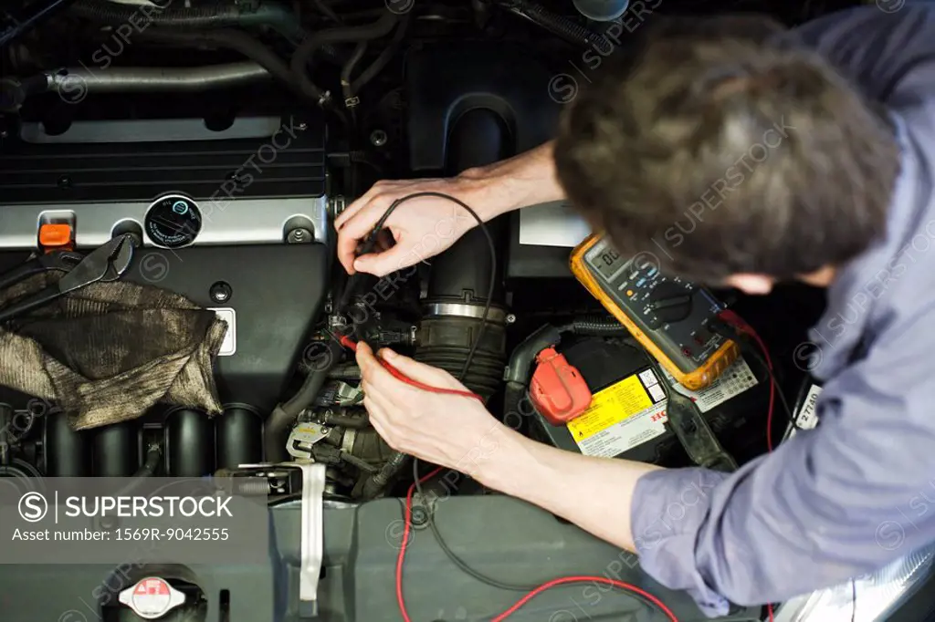 Mechanic diagnosing car engine problem