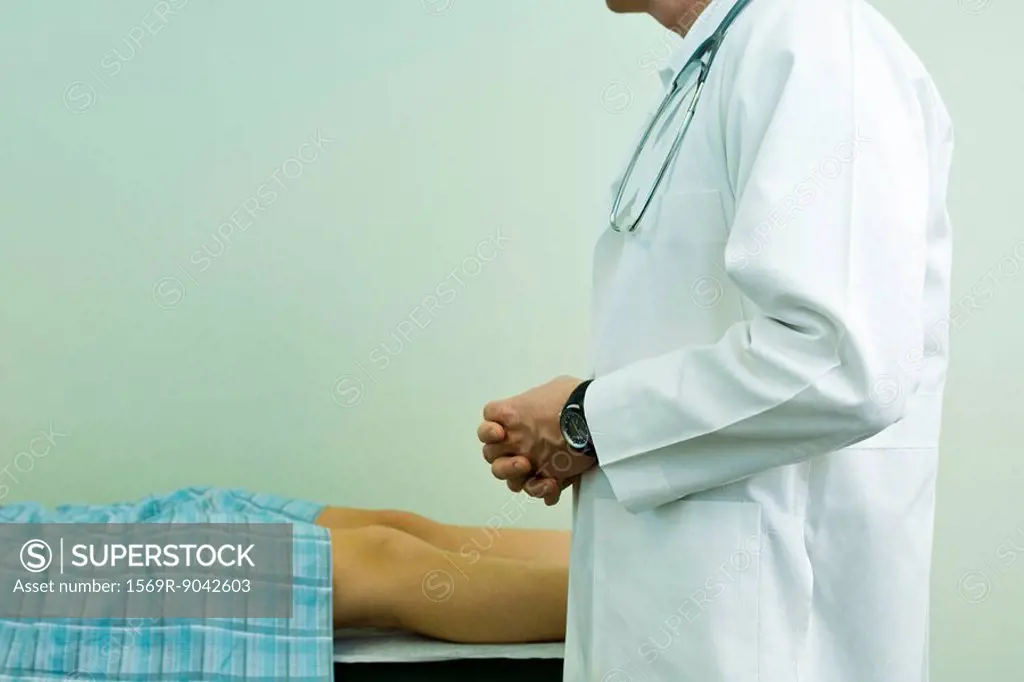 Doctor speaking to patient lying on examination table