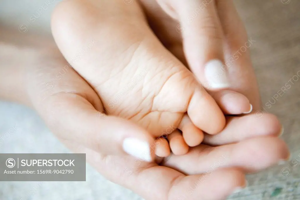Woman´s hands holding baby´s foot