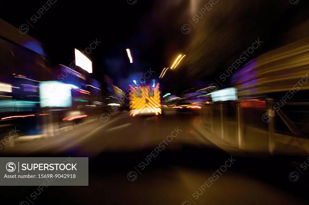 Ambulance rushing down street at night