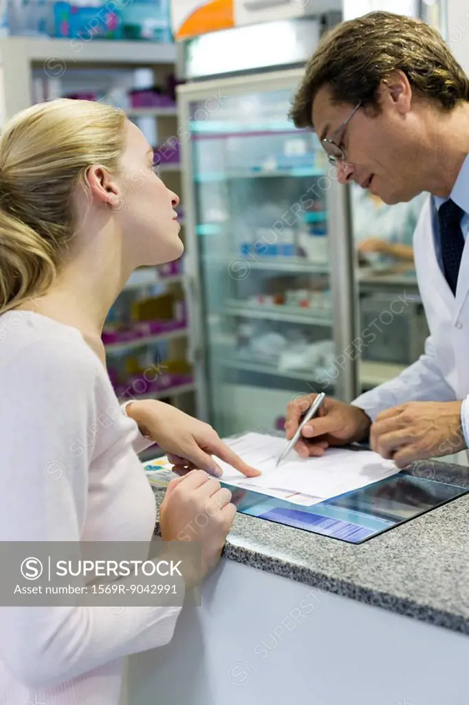Pharmacist explaining prescription to customer