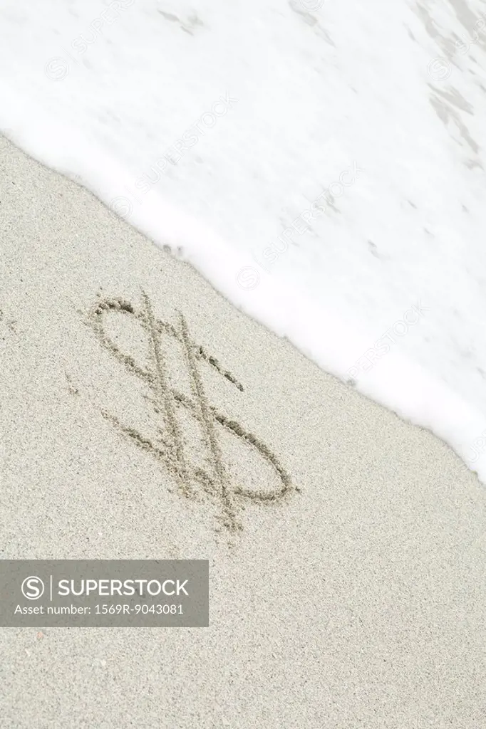 Dollar sign drawn in sand at the beach