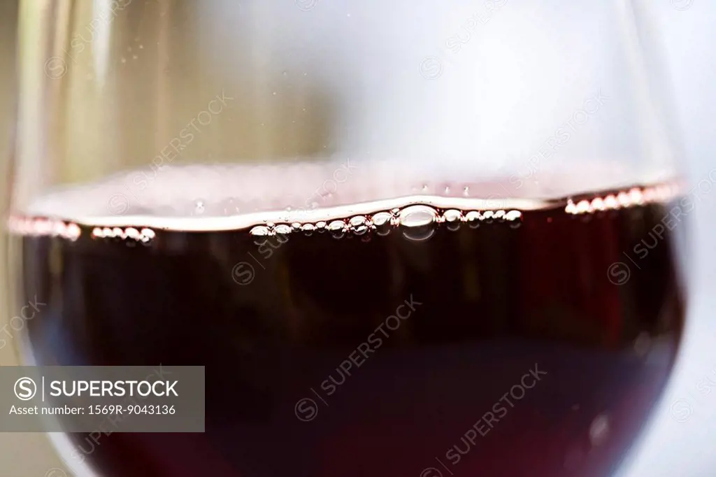 Glass of red wine, bubbles on surface