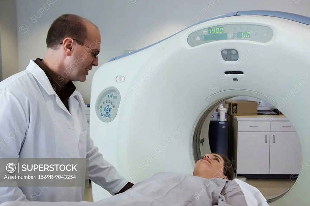 Doctor reassuring nervous female patient preparing to undergo CAT scan
