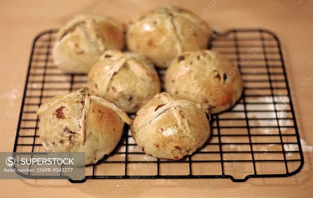 Homemade hot cross buns cooling on rack