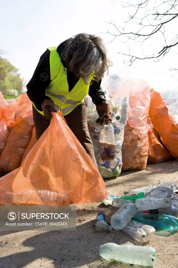 Woman collecting plastic bottles to recycle