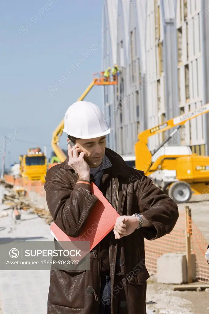 Building contractor using cell phone, checking time