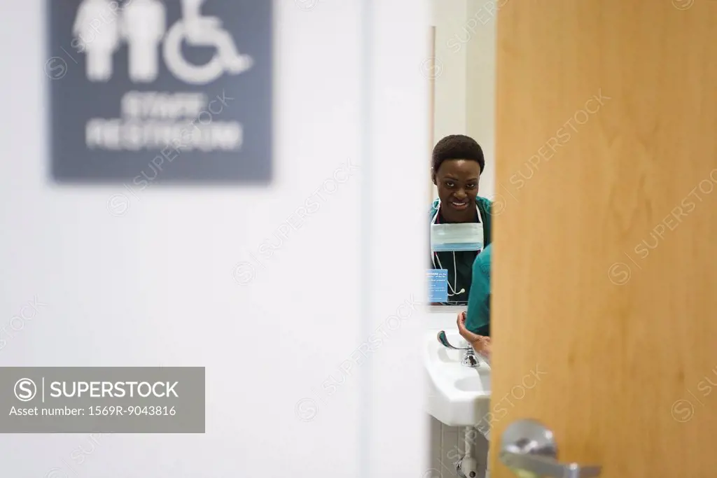 Healthcare worker washing hands in bathroom