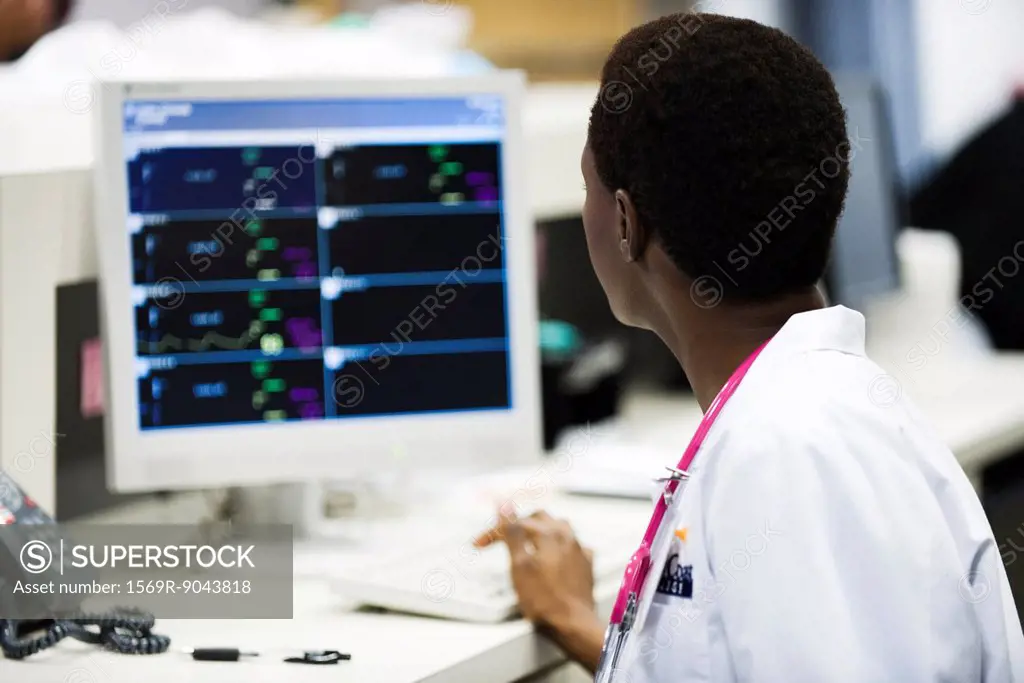 Healthcare worker watching monitor at nurse´s station