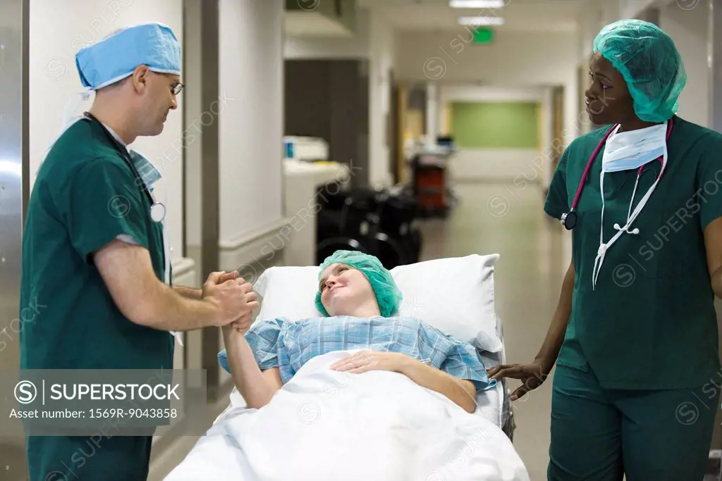 Doctor reassuring patient lying on hospital gurney