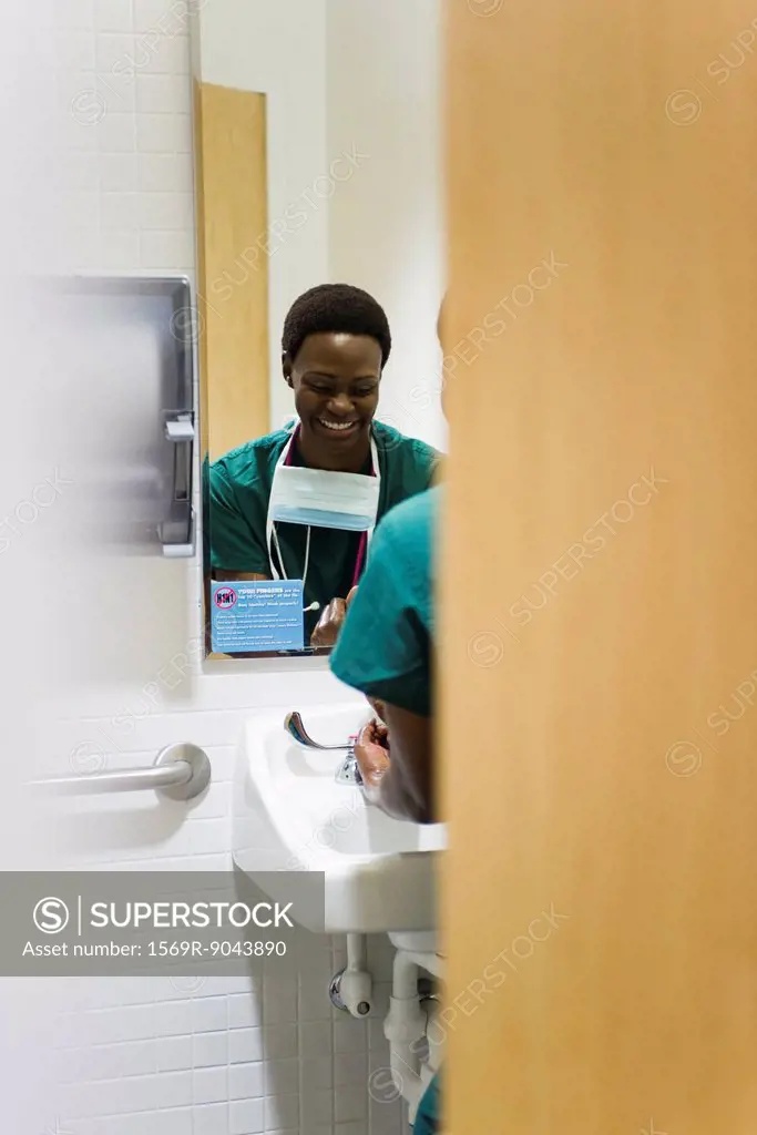 Healthcare worker washing hands in bathroom