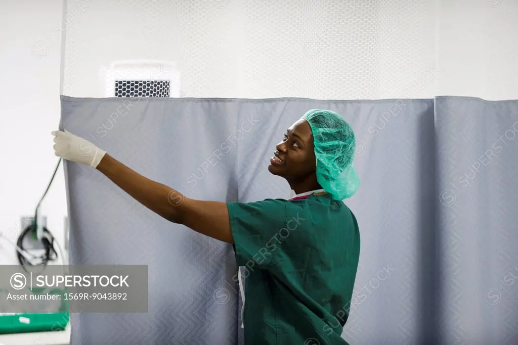 Nurse closing privacy curtain in hospital room