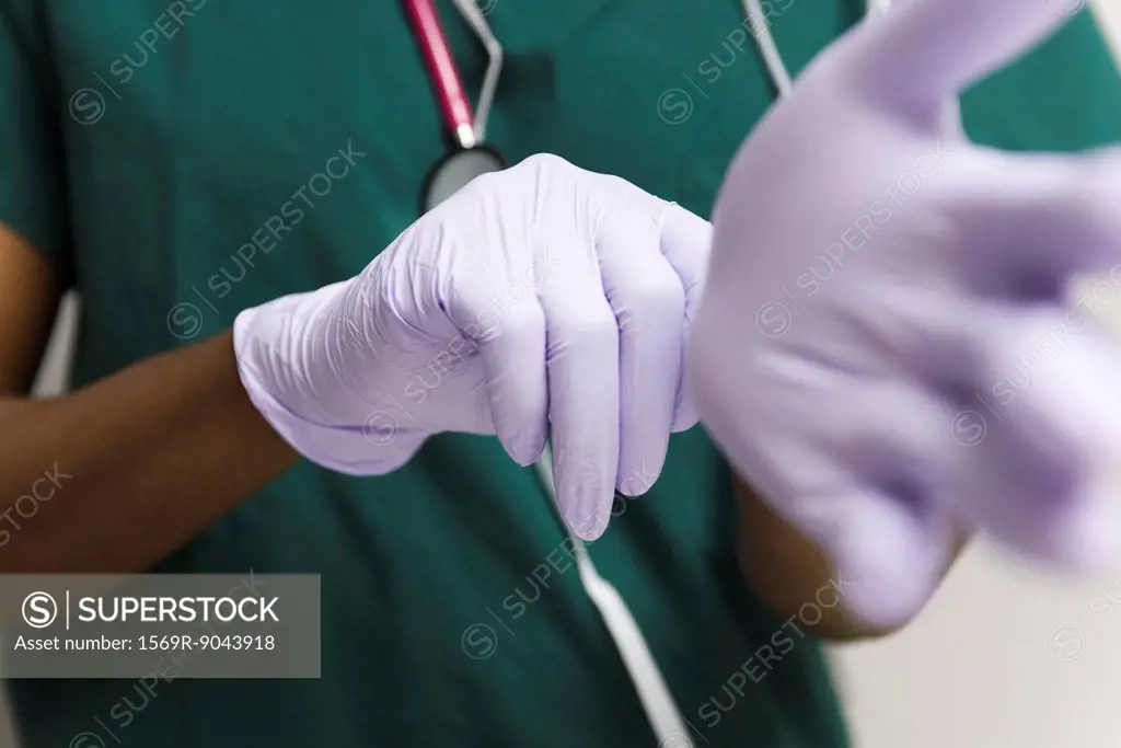 Healthcare worker putting on latex gloves