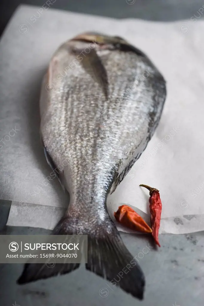 Fresh whole bream with red chili peppers