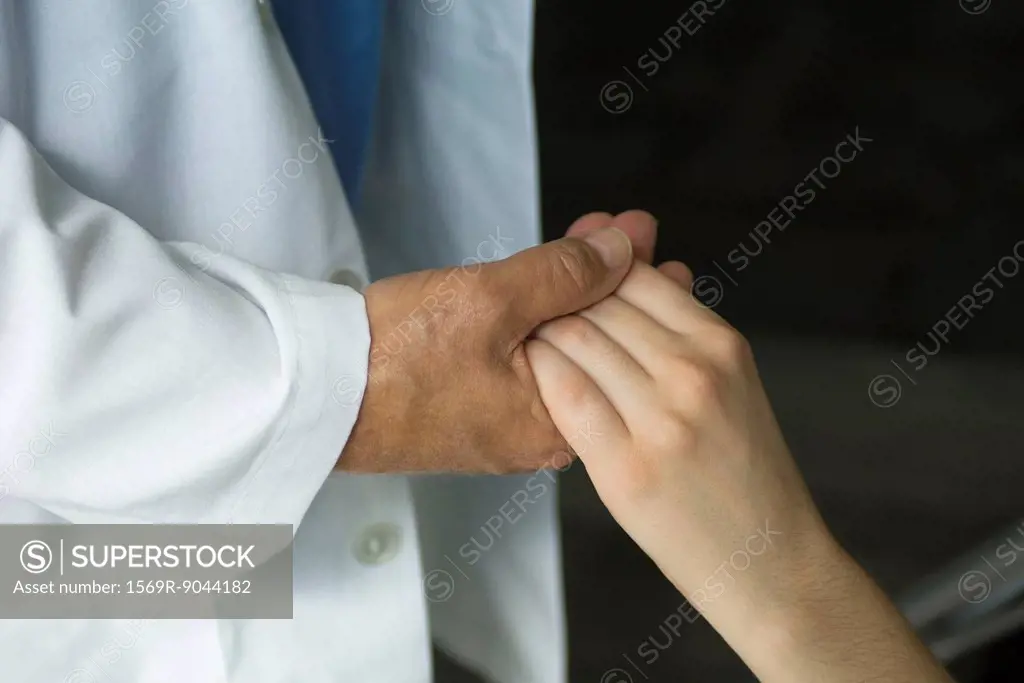 Doctor holding patient´s hand, cropped