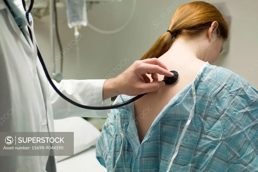 Doctor listening to patient´s back with stethoscope