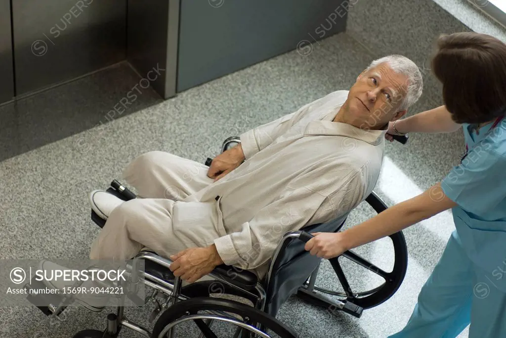 Nurse pushing senior patient in wheelchair