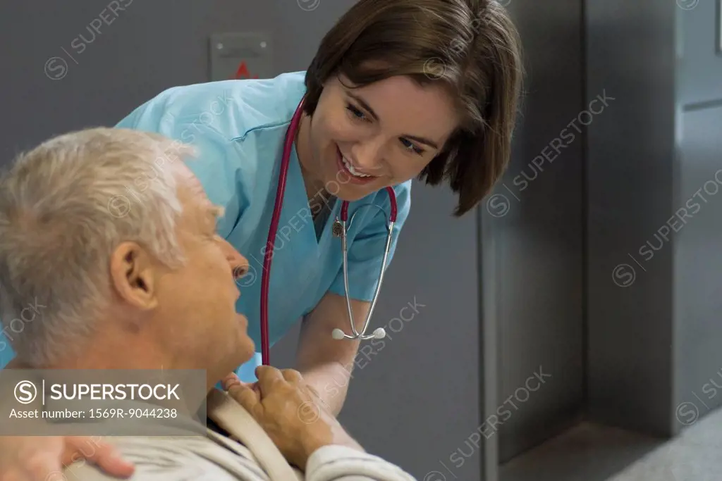 Nurse comforting patient in hospital corridor