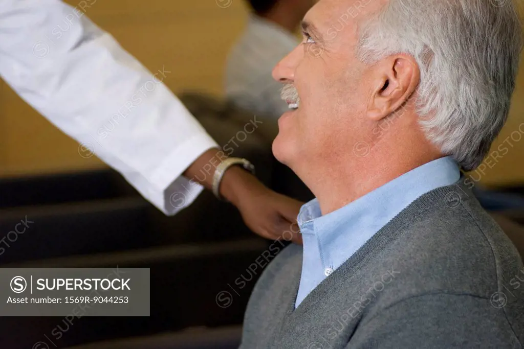 Healthcare worker reassuring man in waiting room