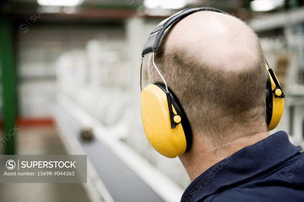 Carpet factory worker wearing sound_proof protective headphones