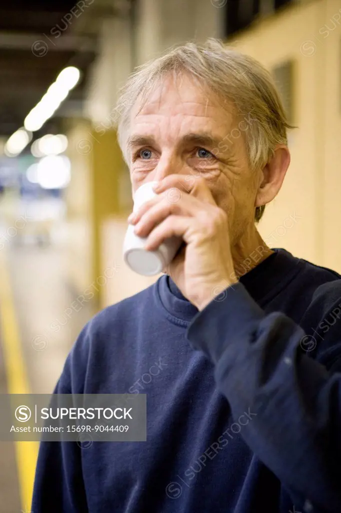 Factory worker drinking cup of coffee