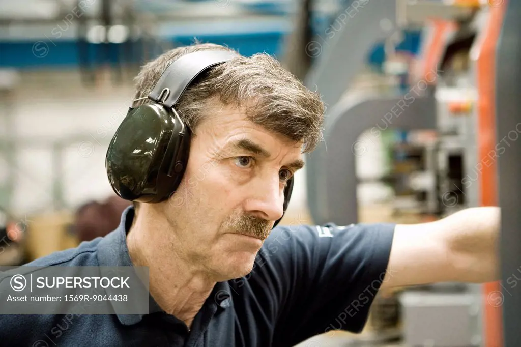 Factory worker wearing protective headphones