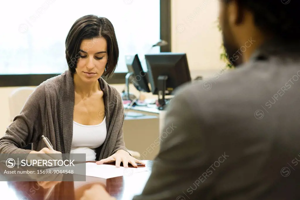 Woman signing document in office