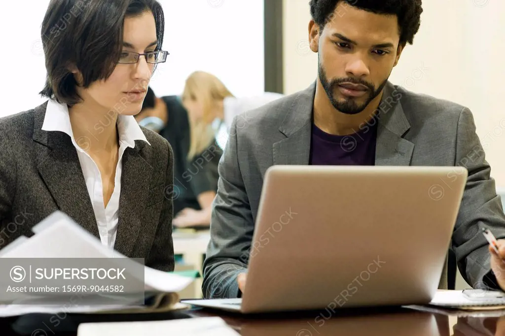 Executives working together on laptop computer