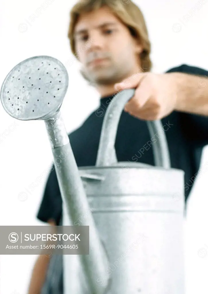 Man holding up watering can