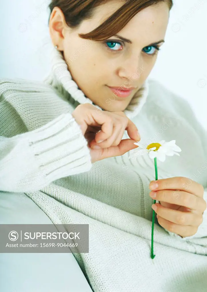 Woman plucking petal from flower