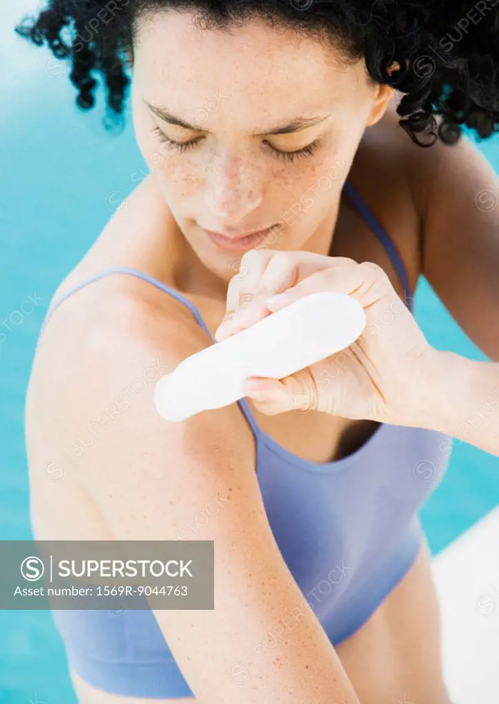 Woman applying sunscreen to arm