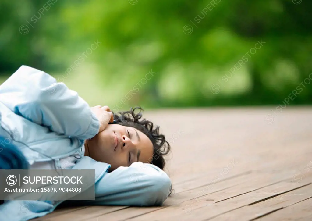 Young woman lying down outdoors