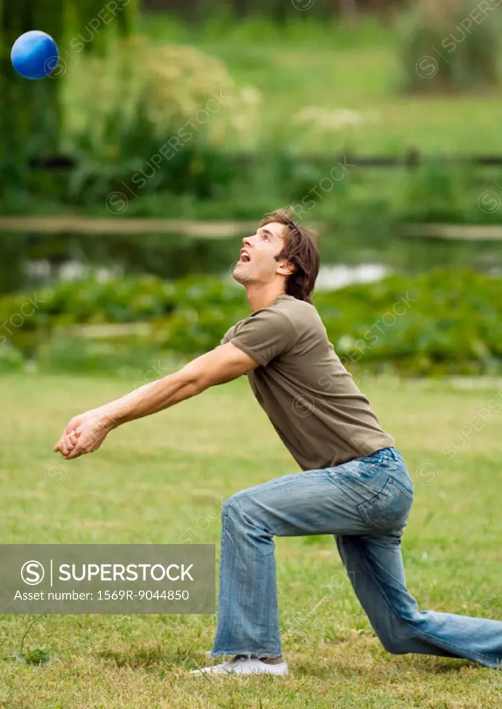Man kneeling to hit volleyball